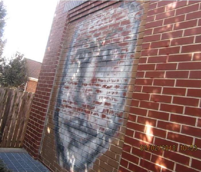 Graffiti face painted on brick building