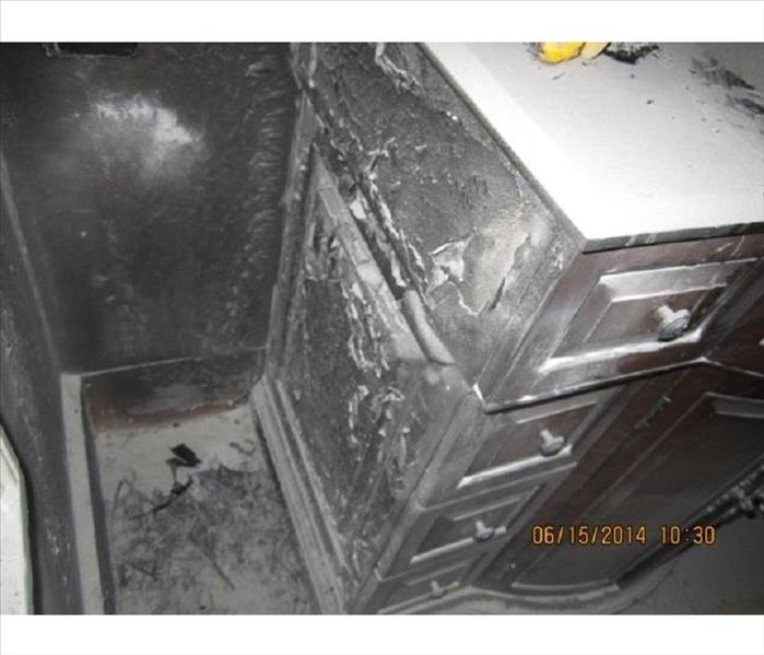 Heavily charred vanity and soot in bathroom