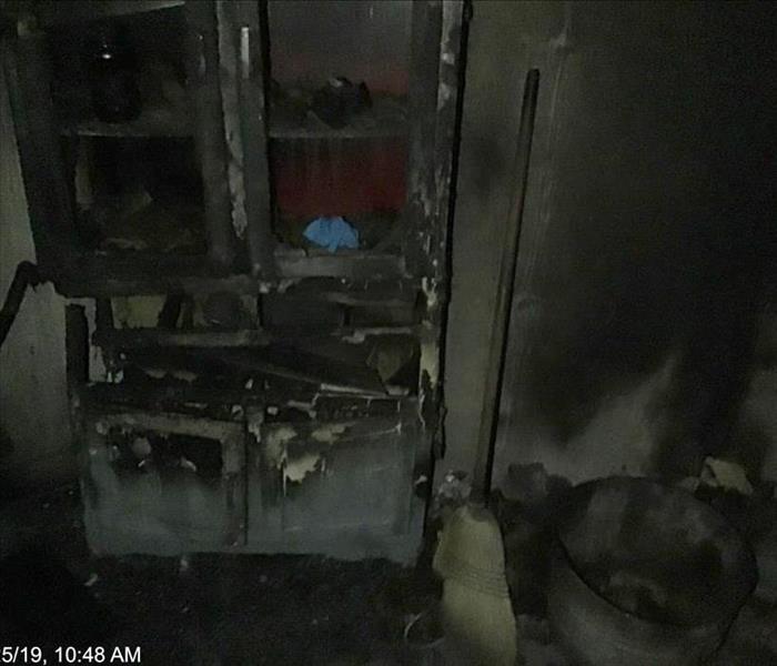Burnt and charred cabinet in completely soot filled room