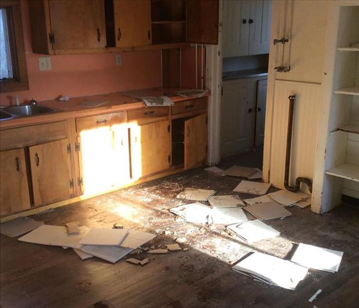 Kitchen ceiling tiles scattered on the wooden floor